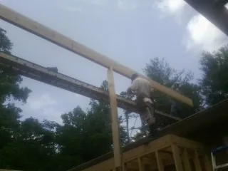 Carpenter setting a ridge beam over a new addition frame — Ice Dam Removal by Roofing Brothers in Shelter Island