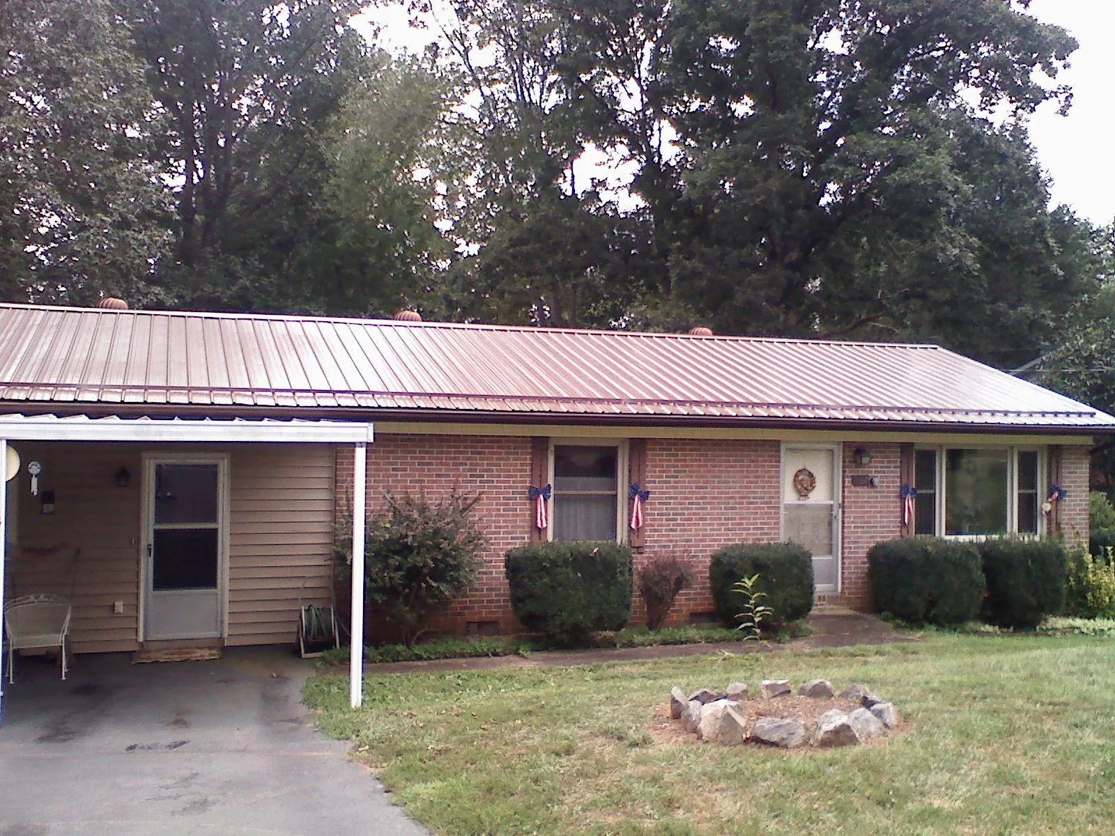Bronze metal roof and carport on a brick ranch home — Roof Repair work by our crew in Shelter Island